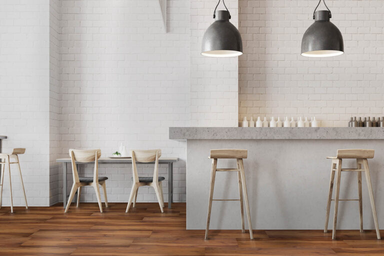 White wall bar interior with a wooden floor, a stone bar and wooden stools near it. Tables with chairs in the background. 3d rendering mock up